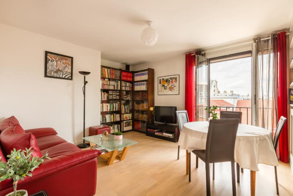 a living room with a red couch and a table at Veeve - Canal Saint Martin Pad in Paris