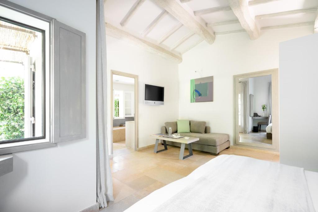 a white living room with a couch and a table at Le Pre de la Mer in Saint-Tropez