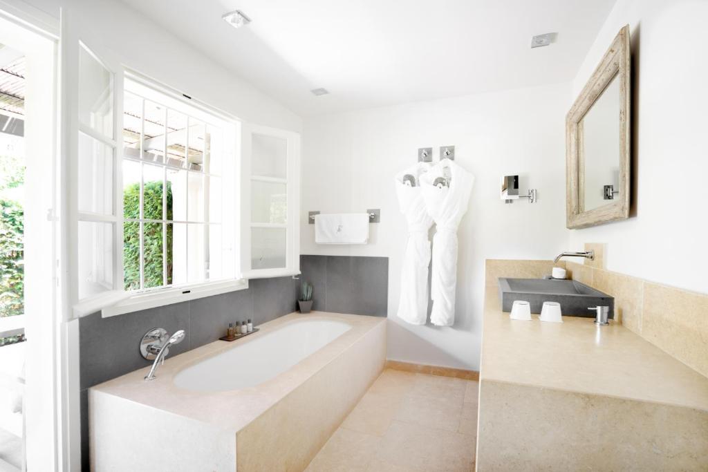 a bathroom with a tub and a sink and a window at Le Pre de la Mer in Saint-Tropez