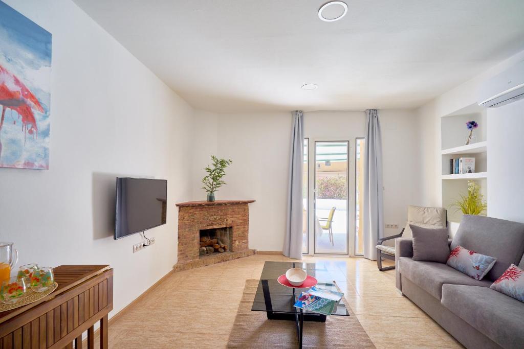 uma sala de estar com um sofá e uma lareira em Villa Rosita Suites en Playa de la Malagueta con terraza em Málaga