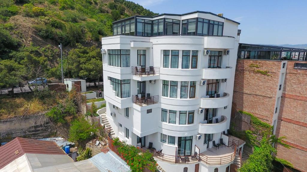 ein weißes Gebäude mit Glasfenstern darüber in der Unterkunft Vista Hotel in Tbilisi City