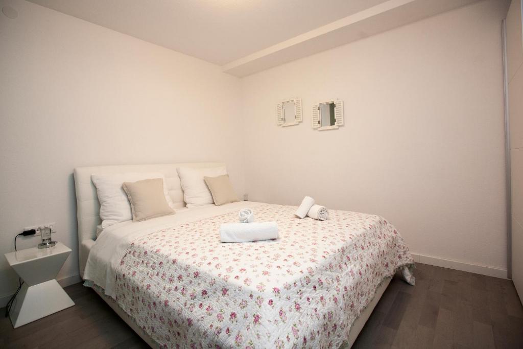 Dormitorio blanco con cama con edredón blanco en Dream Apartment, en Split
