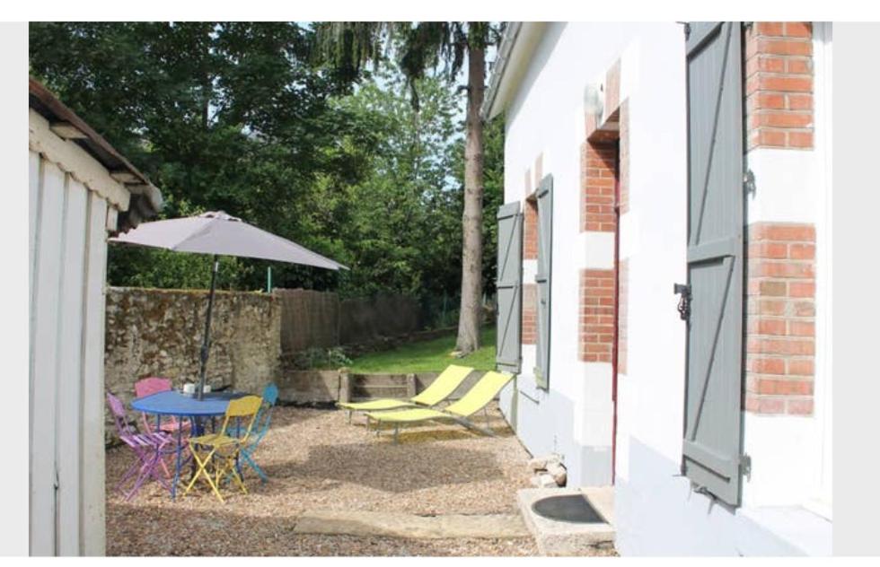 un patio avec une table, des chaises et un parasol dans l'établissement Maison centre-ville avec jardin Blois-Chambord, à Blois