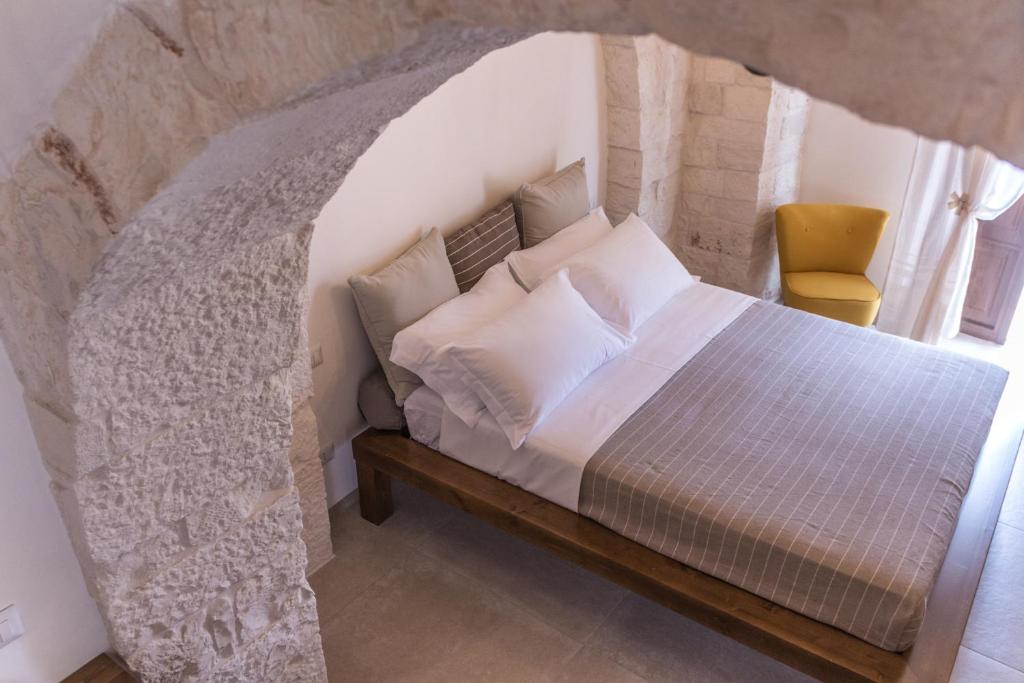 a bedroom with a bed in a stone wall at Trulli Nannì in Locorotondo
