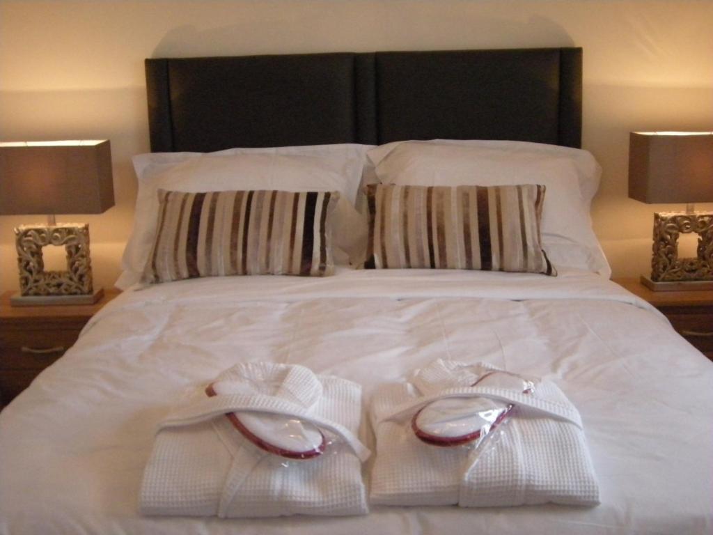 a bed with two white towels and two lamps at Knights Rest Conwy Town 5 Star in Conwy