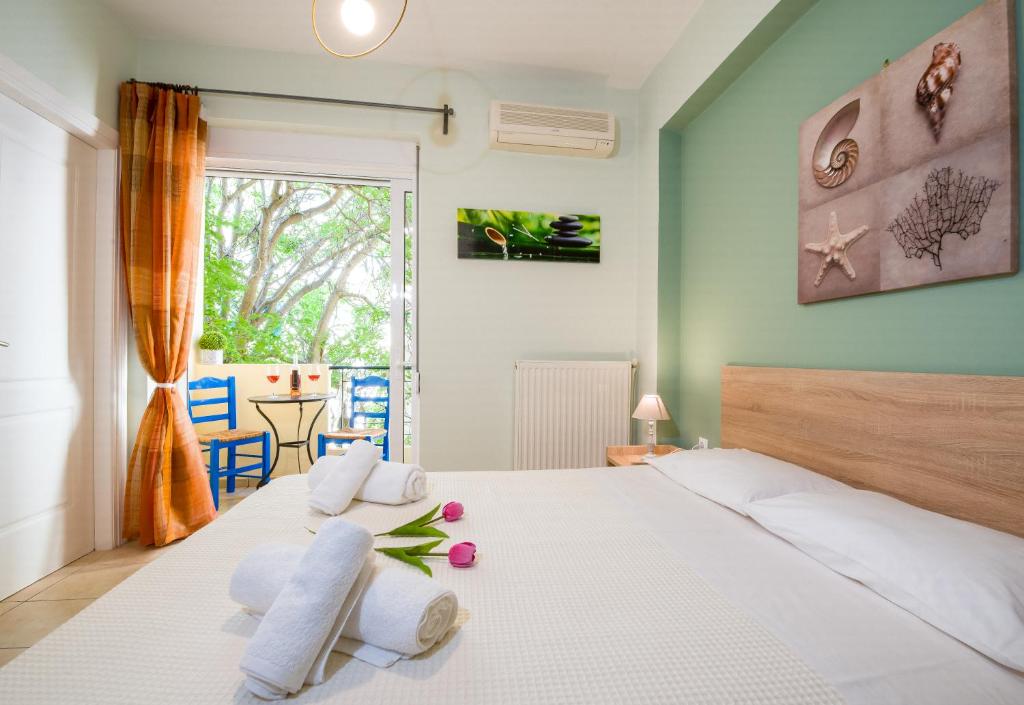a bedroom with a white bed with pillows and a window at Downtown Studio Chania in Chania