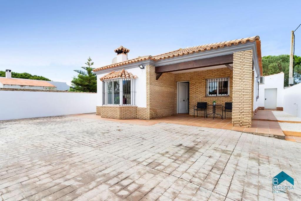 ceglany dom z patio przed nim w obiekcie Villa Maca w mieście Chiclana de la Frontera