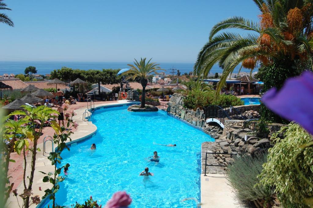 een groep mensen in een zwembad in een resort bij El Capistrano in Nerja