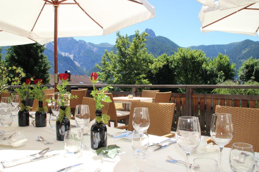 a table with wine glasses and a view of mountains at Hotel Pfleger in Anras