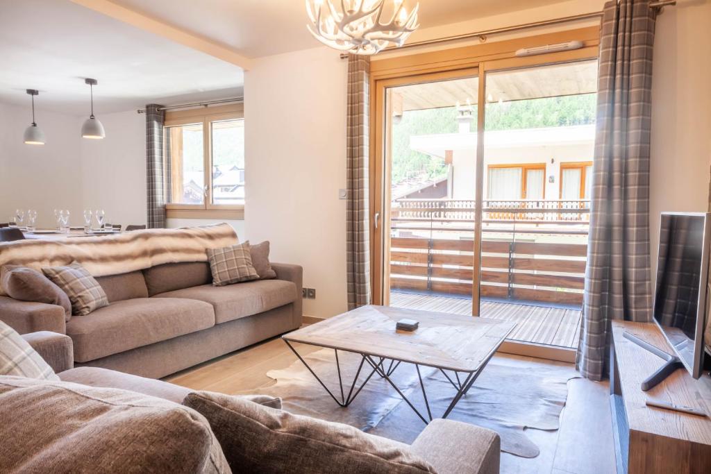 a living room with a couch and a table at PORTES DU PLENEY 101 in Morzine