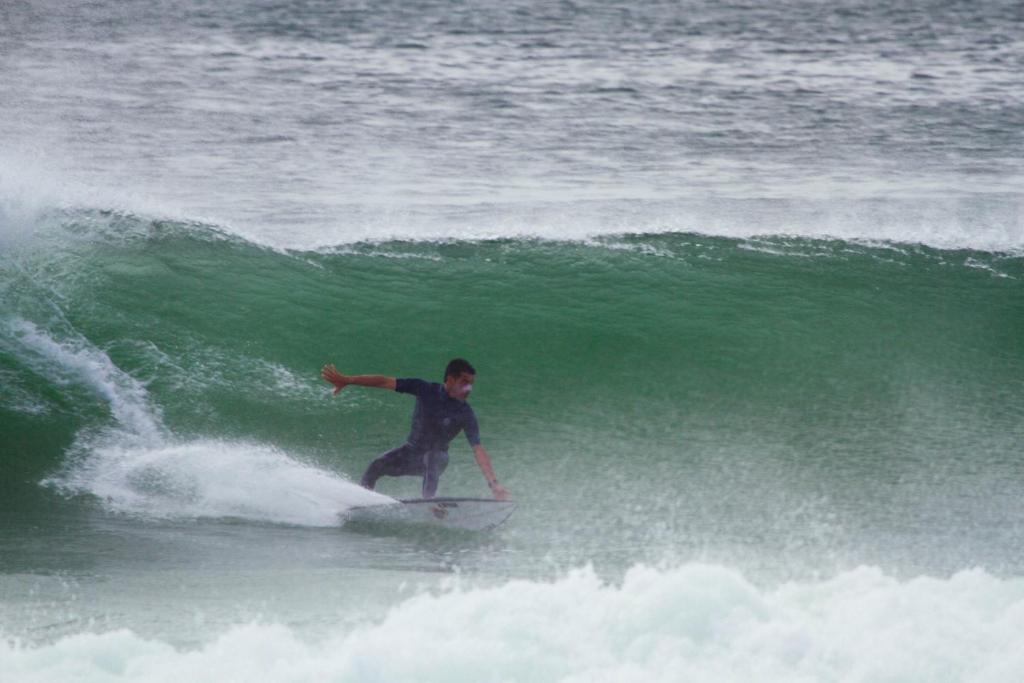 Ein Mann reitet eine Welle auf einem Surfbrett im Ozean in der Unterkunft Surfhostel Hossegor in Soorts-Hossegor