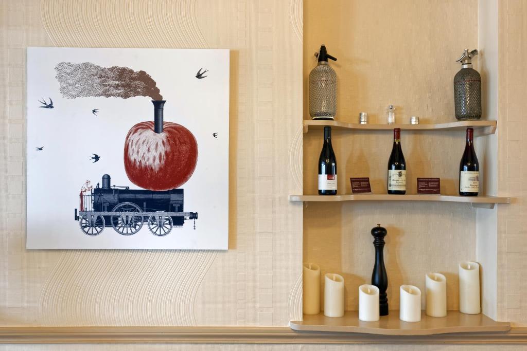 a shelf with bottles of wine and a picture of an apple at Contact Hôtel du Commerce et son restaurant Côte à Côte in Autun