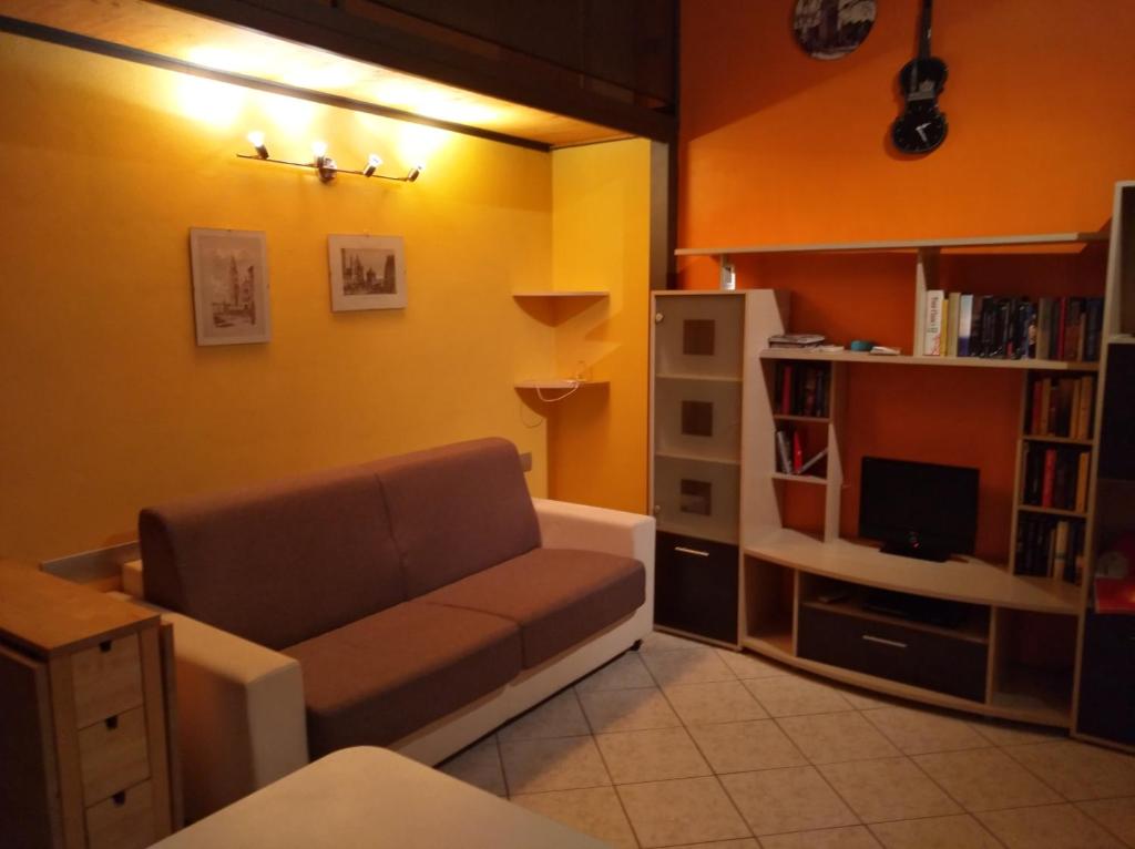 uma sala de estar com um sofá e uma estante de livros em Casa vacanze IL VIOLINO em Cremona