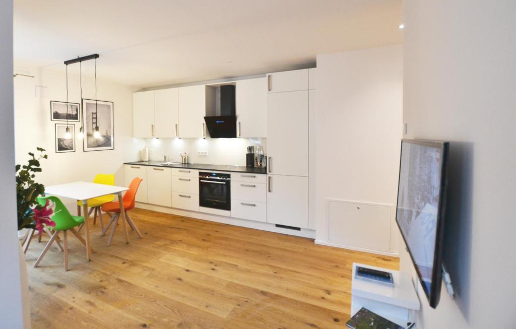 a kitchen with white cabinets and a table and chairs at Modern apartment near downtown in Munich