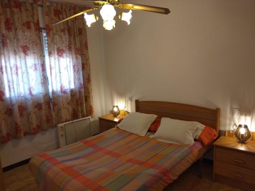1 dormitorio con 1 cama con 2 mesitas de noche y una ventana en Apartamento Guillem, en Riumar