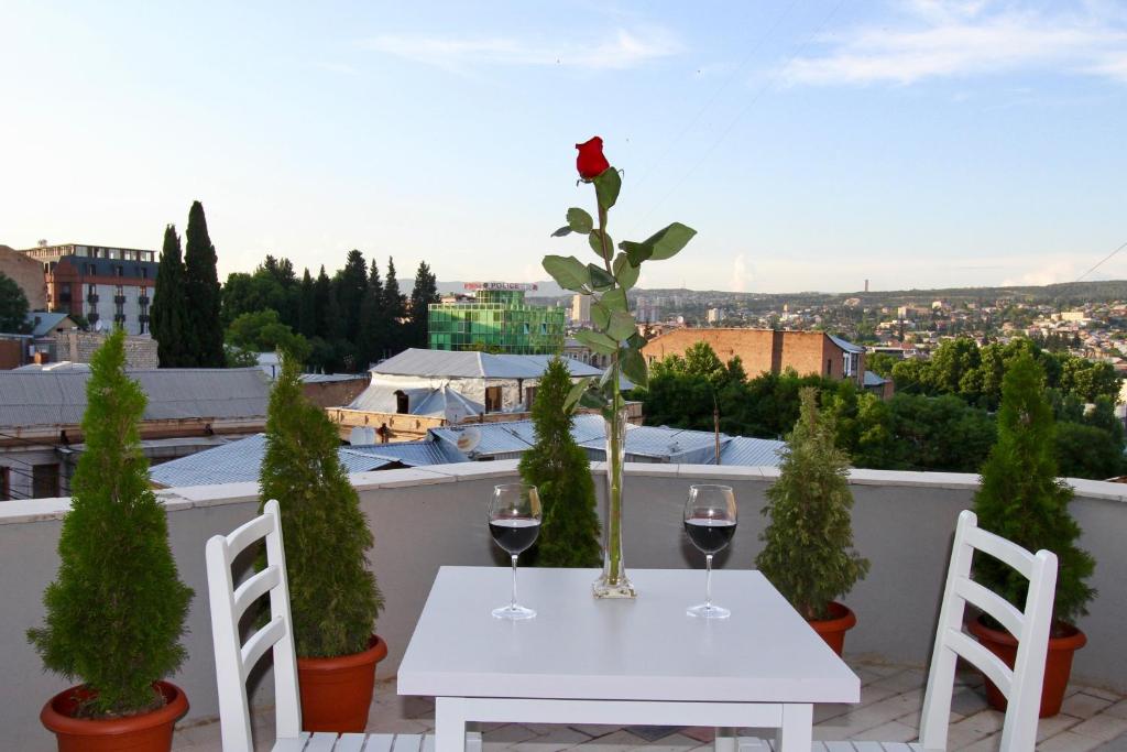 a white table with two glasses of wine on a balcony at Apart-hotel TARHUN in Tbilisi City