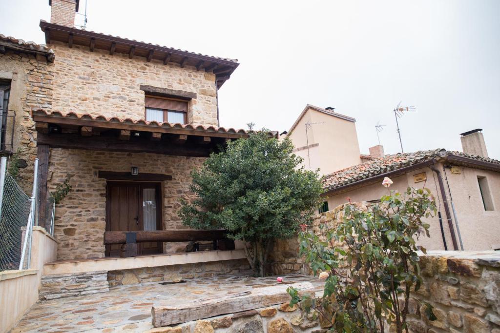 a stone house with a staircase leading up to the door at Los Acebos in Horcajuelo de la Sierra