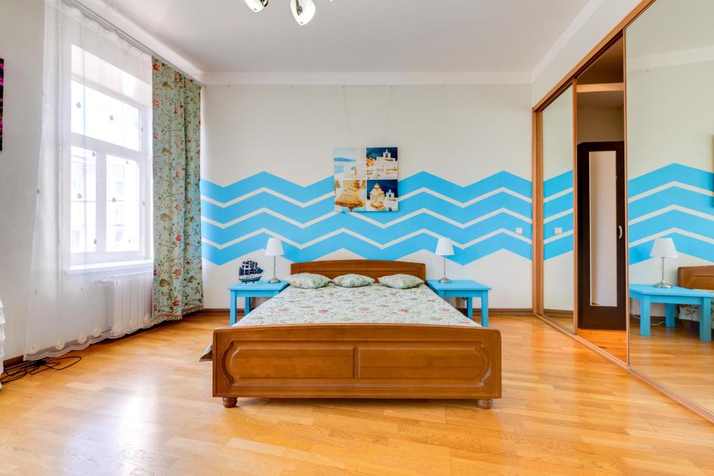 a bedroom with a bed and a blue and white wall at Apartment on Griboyedova 38 in Saint Petersburg