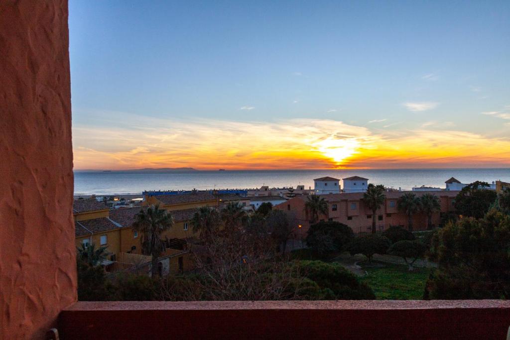 een uitzicht op de zonsondergang vanuit een gebouw bij Livingtarifa Apartamento La Duna in Tarifa