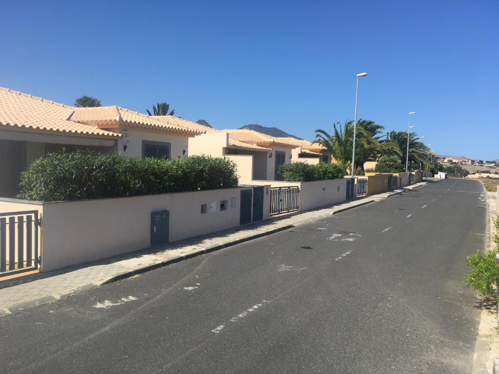 an empty street with houses and a fence at casa de praia Nunes Village in Porto Santo