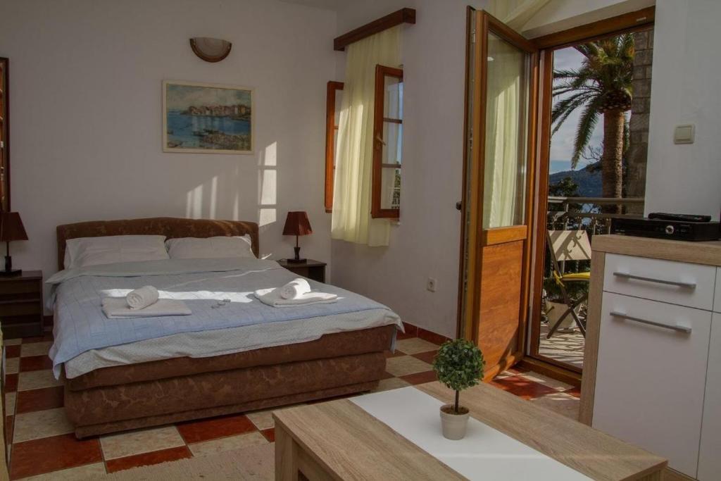 a bedroom with a bed and a view of a balcony at Apartmani Skver Sanja in Herceg-Novi