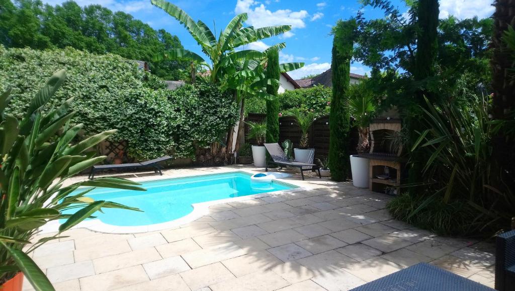 a swimming pool in a yard with a patio at Le patio d'olivier in Lalinde