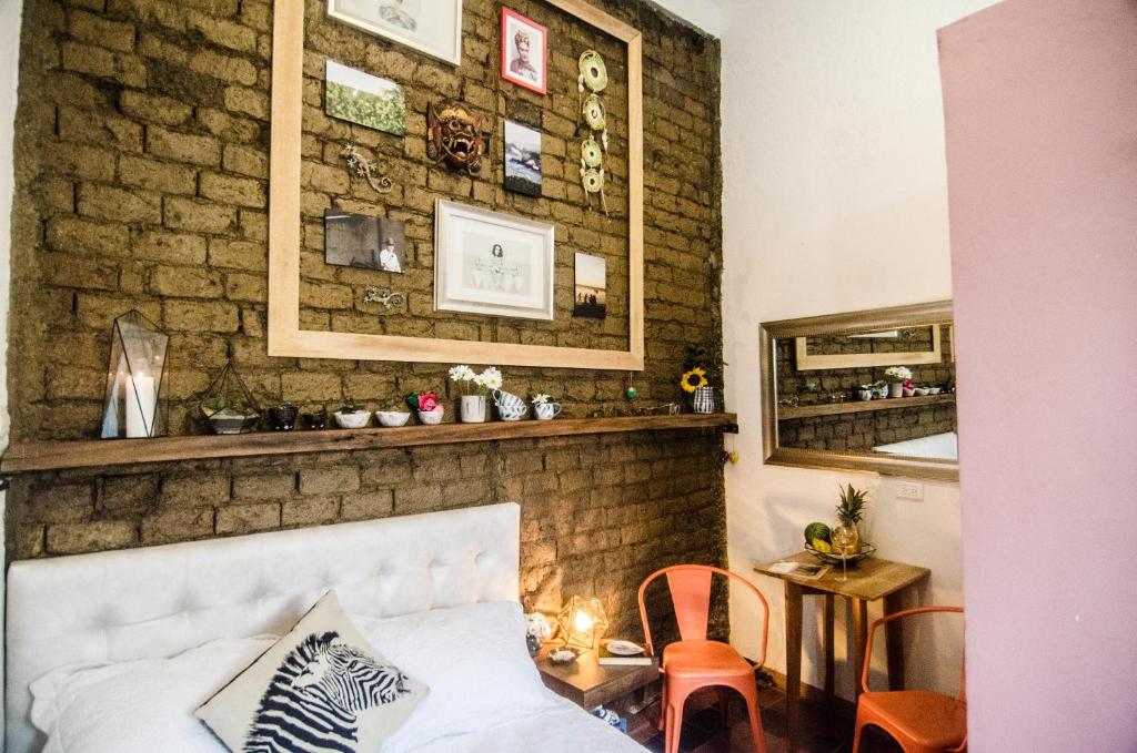 a room with a bed and a brick wall at Moonshine Boutique Hostal in Cali