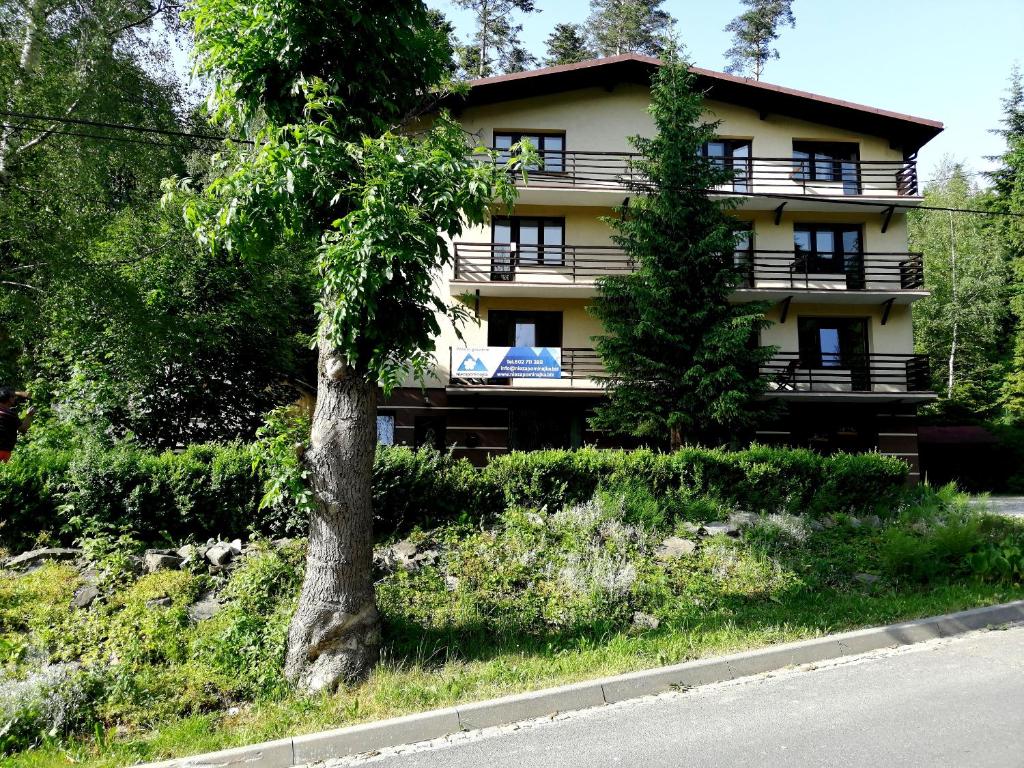 a building with a tree in front of it at NIEZAPOMINAJKA in Szczyrk