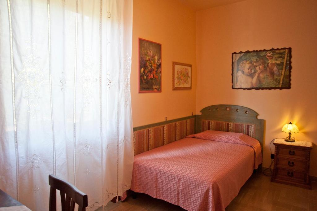 sypialnia z łóżkiem z czerwoną narzutą w obiekcie Casa Donatella sulla costa degli Etruschi w mieście Rosignano Solvay