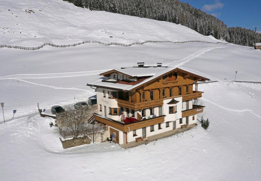 a large wooden house in the snow at Haus Windegg in Tux