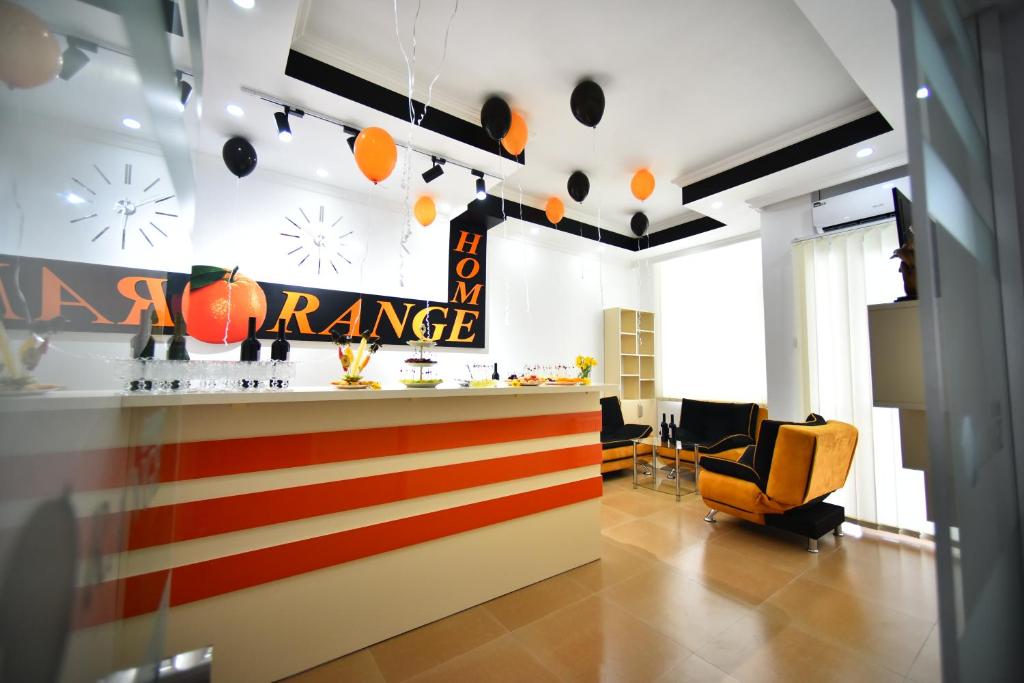 an office lobby with an orange sign on the wall at Orange Home Hotel in Batumi