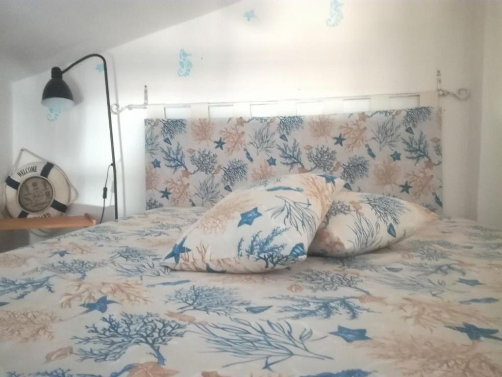 un letto con lenzuola e cuscini blu e bianchi di Villino Nuoro a San Teodoro
