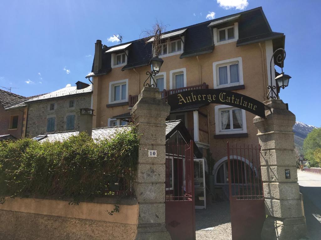 a building with a gate in front of a house at L'Auberge Catalane in Latour-de-Carol