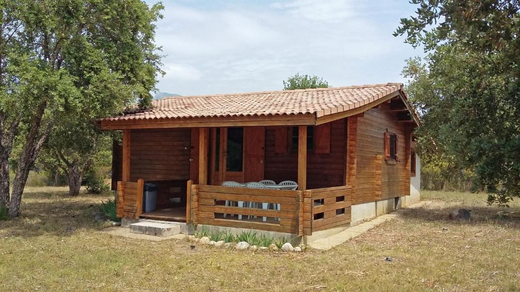 eine kleine Holzhütte auf einem Feld mit Bäumen in der Unterkunft chalet Porticcio Corse in Fontanaccio