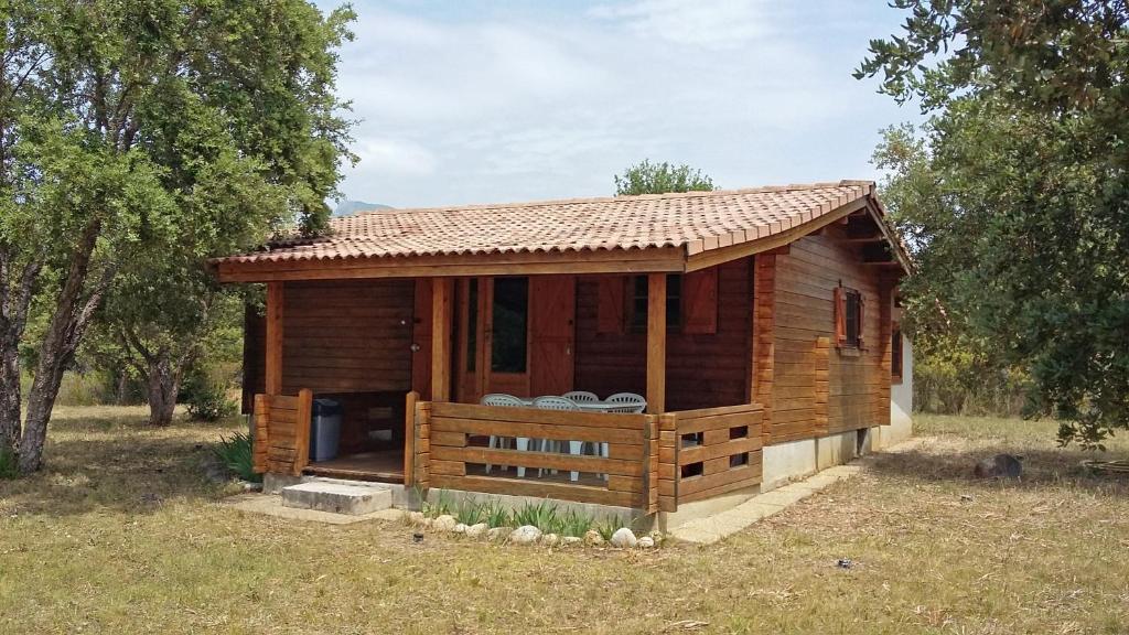 une petite cabane en bois dans un champ arboré dans l'établissement chalet climatisé Porticcio Corse, à Fontanaccio