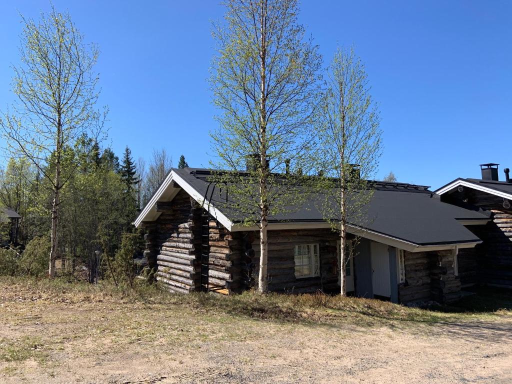 una casa de madera con árboles delante de ella en Rukankuukkeli b13, en Kuusamo