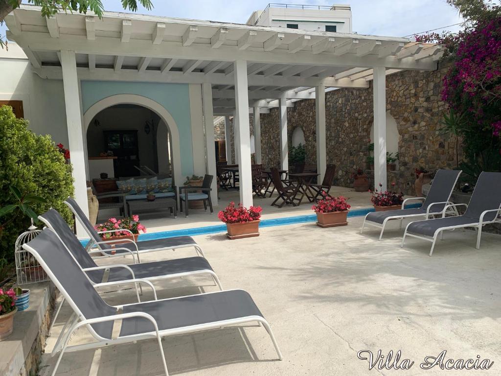 a group of lounge chairs sitting on a patio at Villa Acacia in Ponza