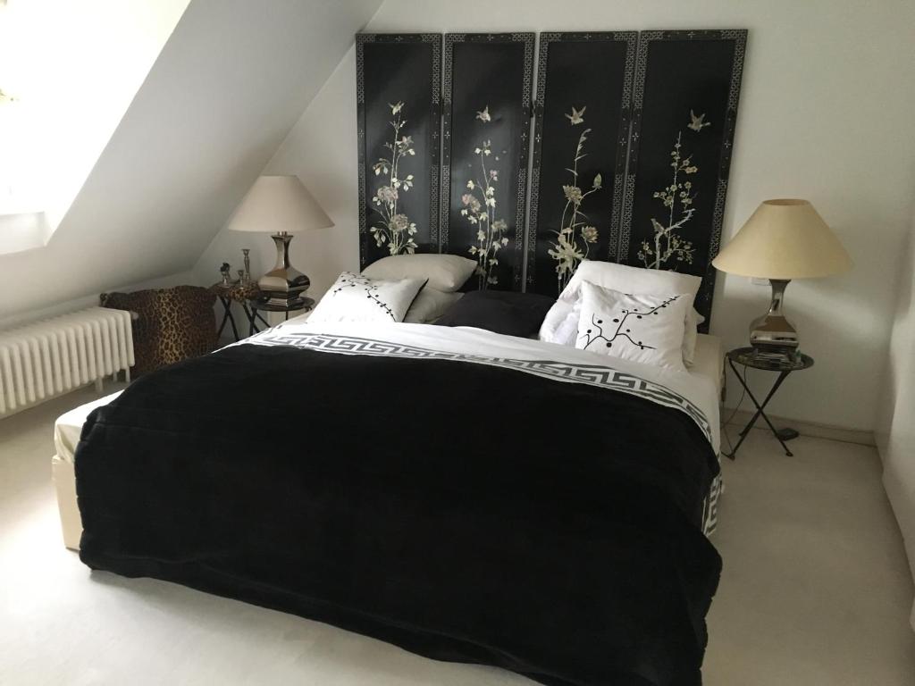 a bedroom with a black bed with white pillows at Einfamilienhaus im Landhausstil in Meerbusch