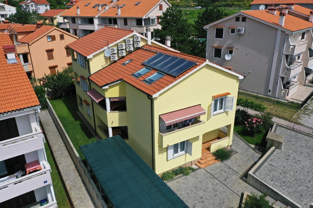 una casa con una matriz solar en su techo en Apartments Luni, en Baška