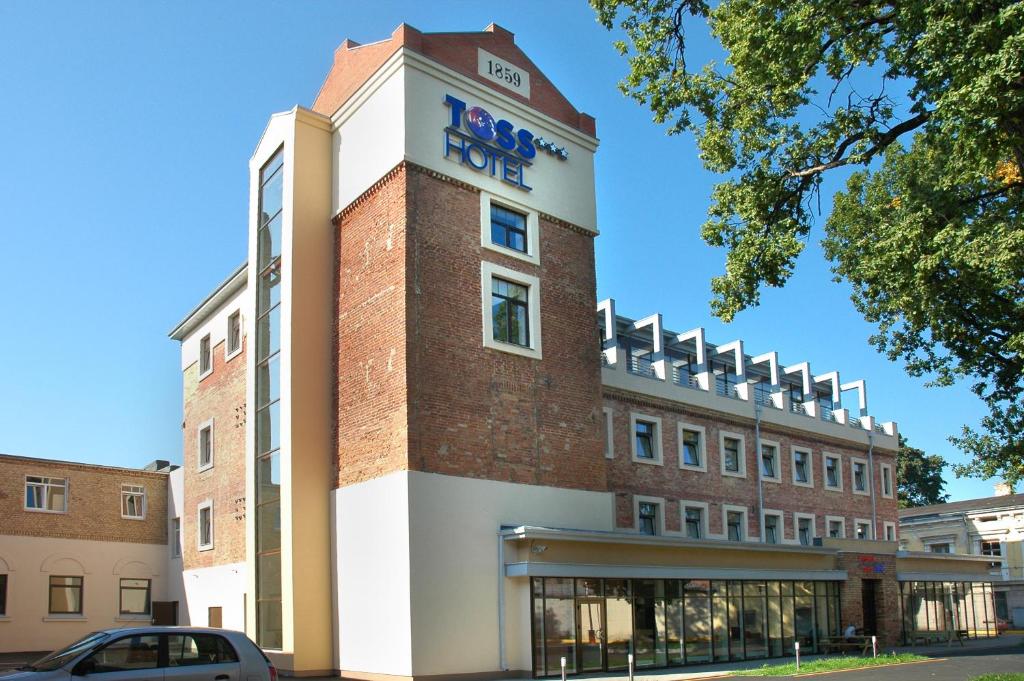 a building with a sign on the side of it at TOSS Hotel in Riga