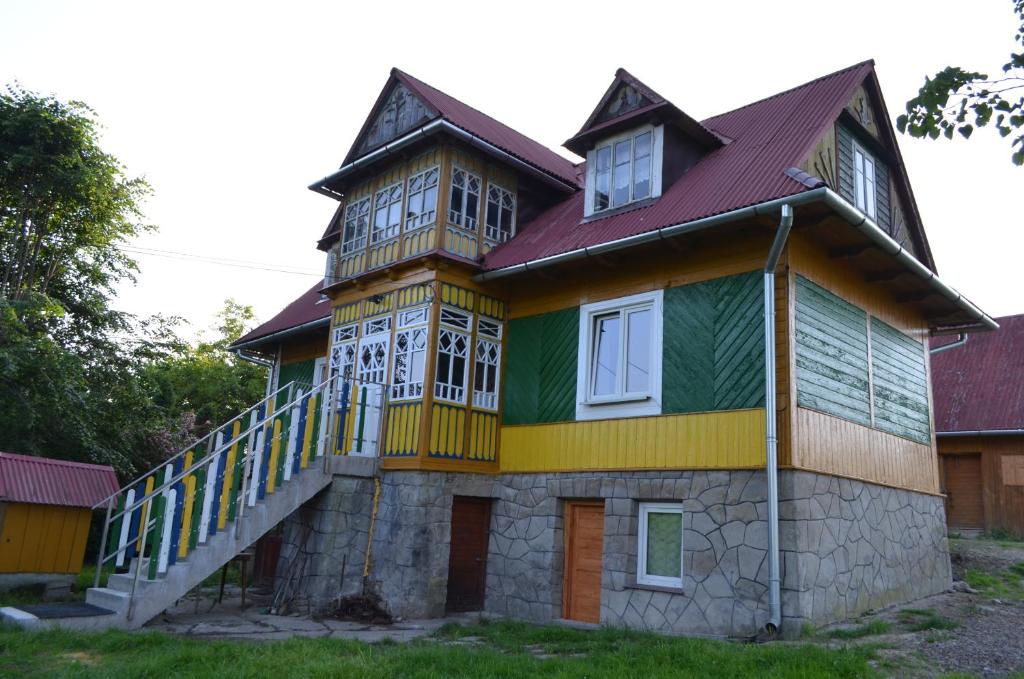 une maison peinte en jaune vert et orange dans l'établissement Kolorowy Domek, à Kasina Wielka