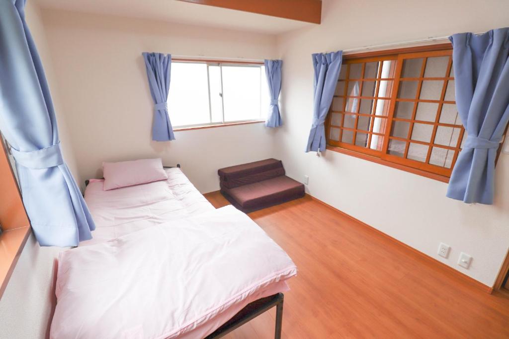 1 dormitorio con 2 camas y ventana en Saitama Niiza House / Vacation STAY 4274 en Niiza