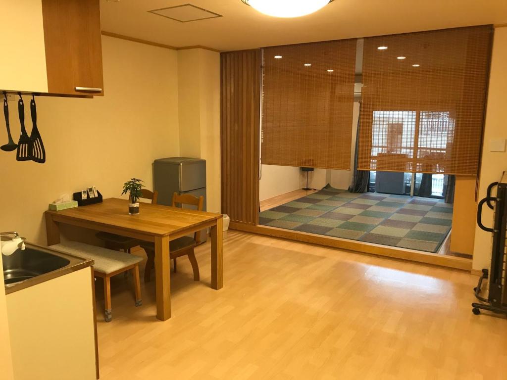 uma cozinha com uma mesa e uma sala de jantar em HOSTEL PAQ tokushima / Vacation STAY 35580 em Tokushima