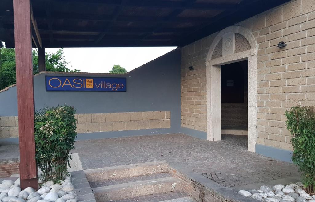 a building with a sign that reads oasis village at Oasi Club Village in Rocca dʼEvandro