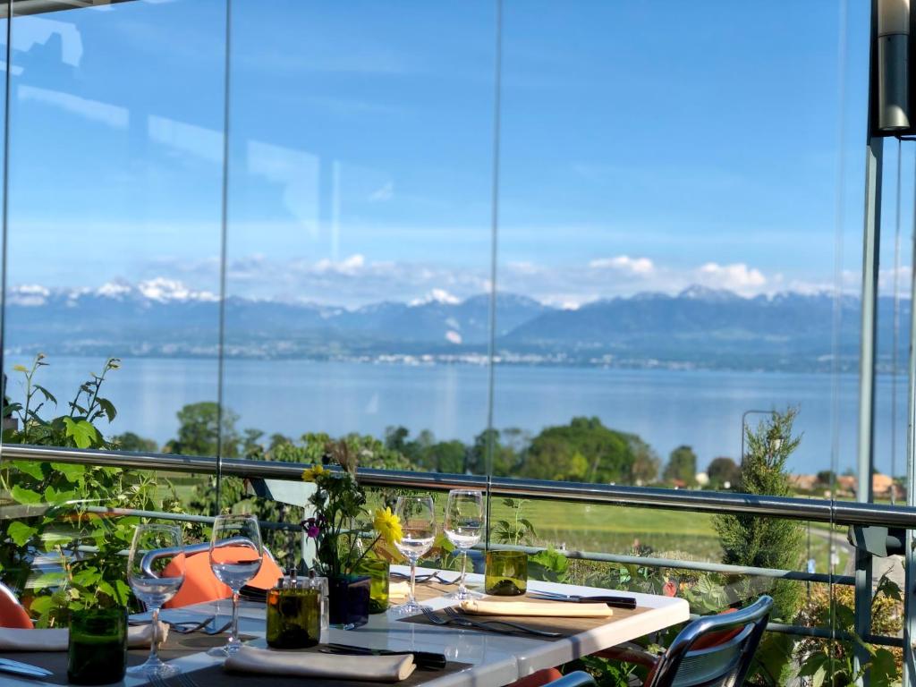 a table with a view of the water and mountains at La Clef D'Or Auberge Communale in Bursinel