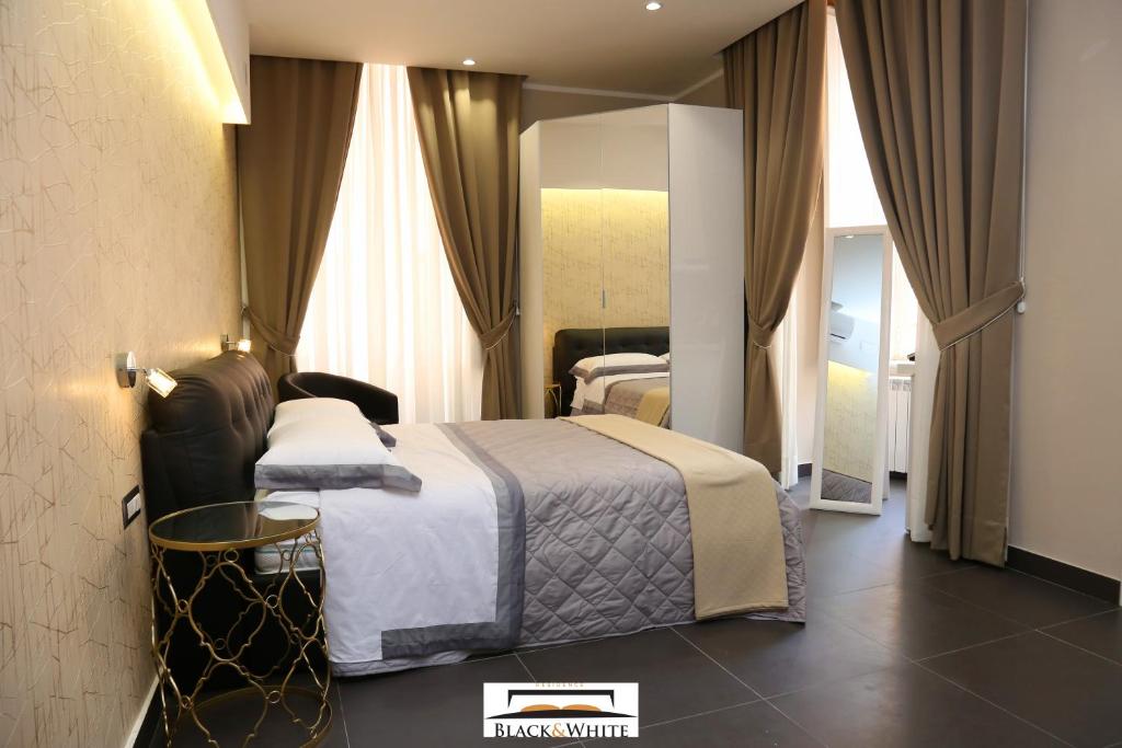 - une chambre d'hôtel avec un lit et un miroir dans l'établissement Residence Black & White, à Naples