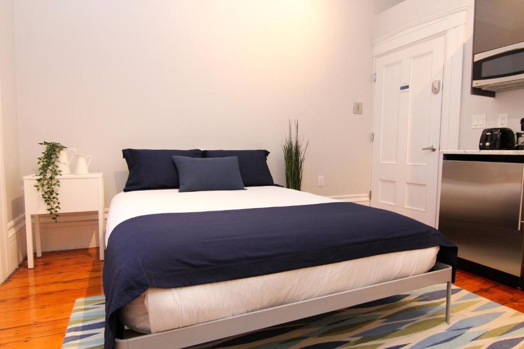 1 dormitorio con 1 cama con sábanas azules y blancas en Cozy Furnished Studio in Beacon Hill #4 en Boston