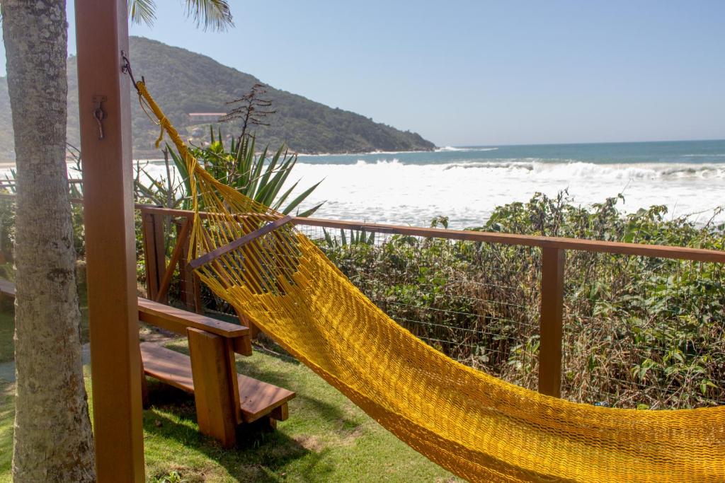 una hamaca en un porche con vistas a la playa en Pousada Hibisco, en Bombinhas