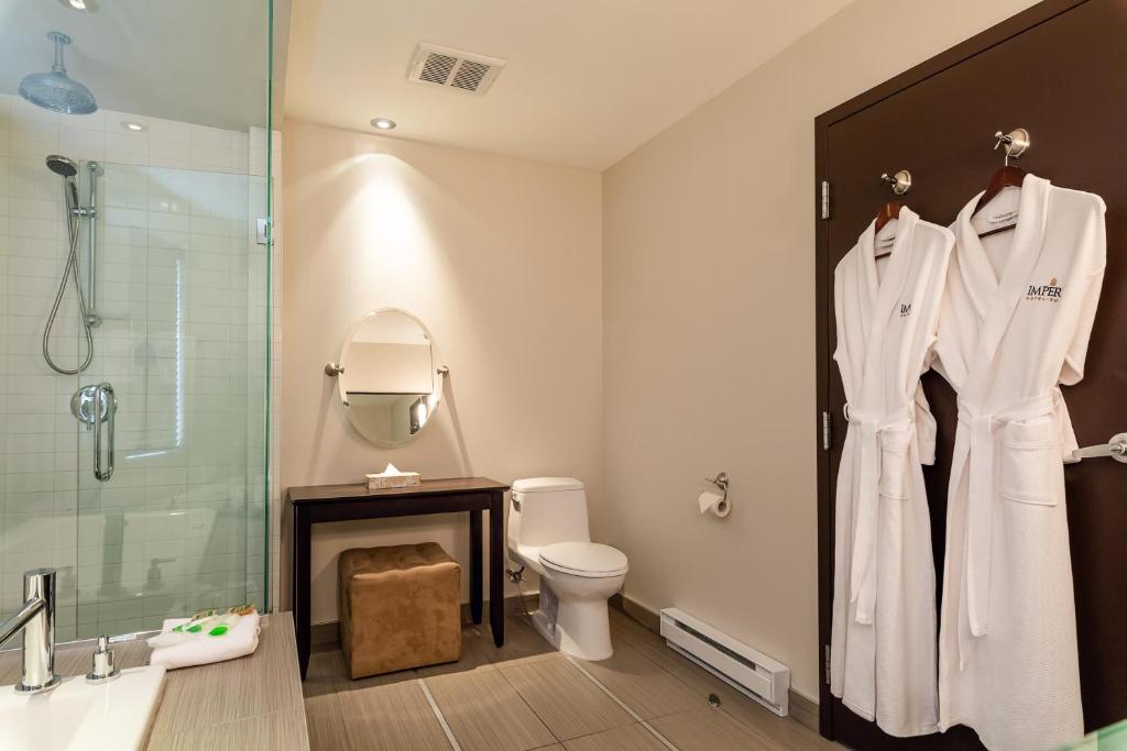 a bathroom with a toilet and a glass shower at Imperia Hotel & Suites Saint-Eustache in Saint-Eustache