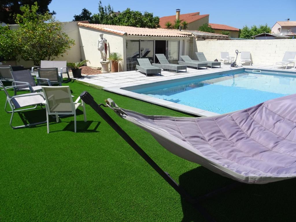 a hammock on the grass next to a swimming pool at L'Escala in Argelès-sur-Mer